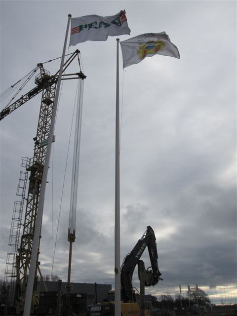 Byggkranen är på plats bredvid flaggorna.